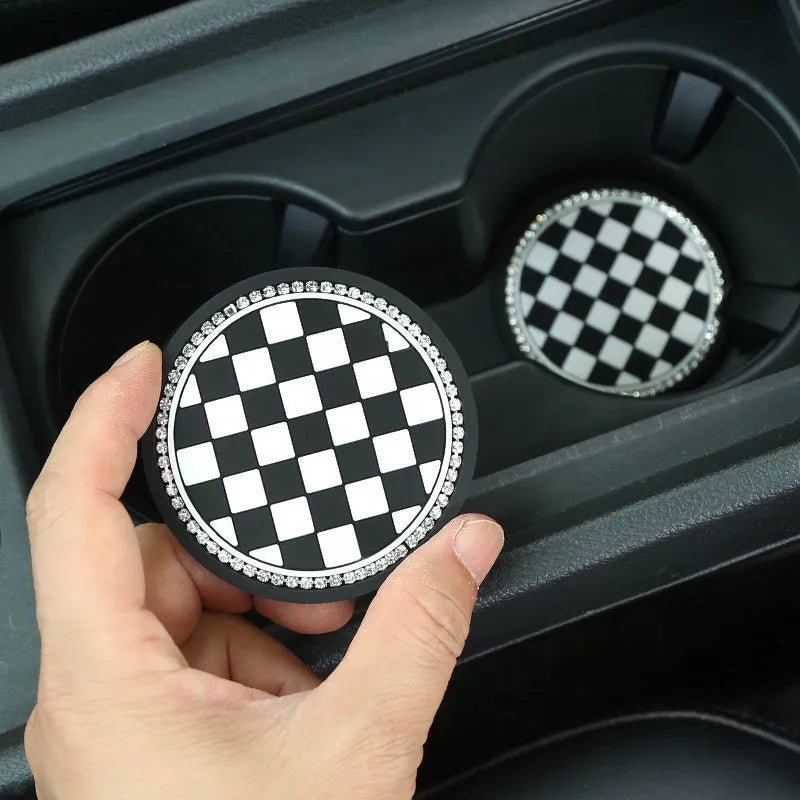 Black and white checkerboard pattern PVC plastic car cup holder mat placed in a vehicle centre console.