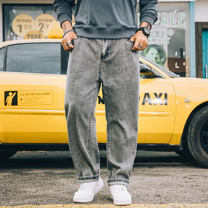 Men's loose straight blue jeans on hanger showing mid-waist design and straight leg cut