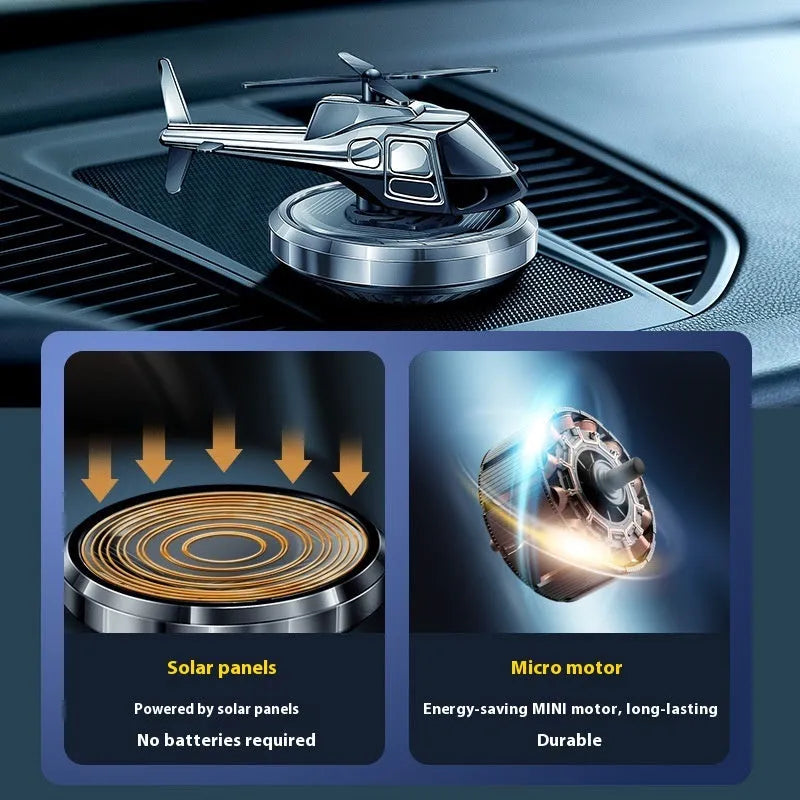 Silver solar powered rotating helicopter car perfume ornament on vehicle dashboard