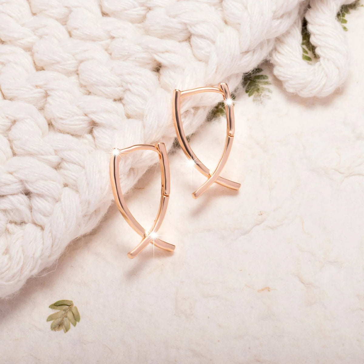 Rose gold cross shaped drop earrings with copper construction and light luxury finish