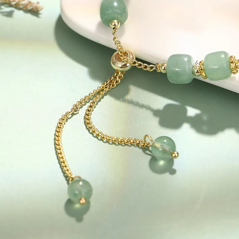 Rabbit charm bracelet with green aventurine and strawberry quartz stones on a gold or copper chain.