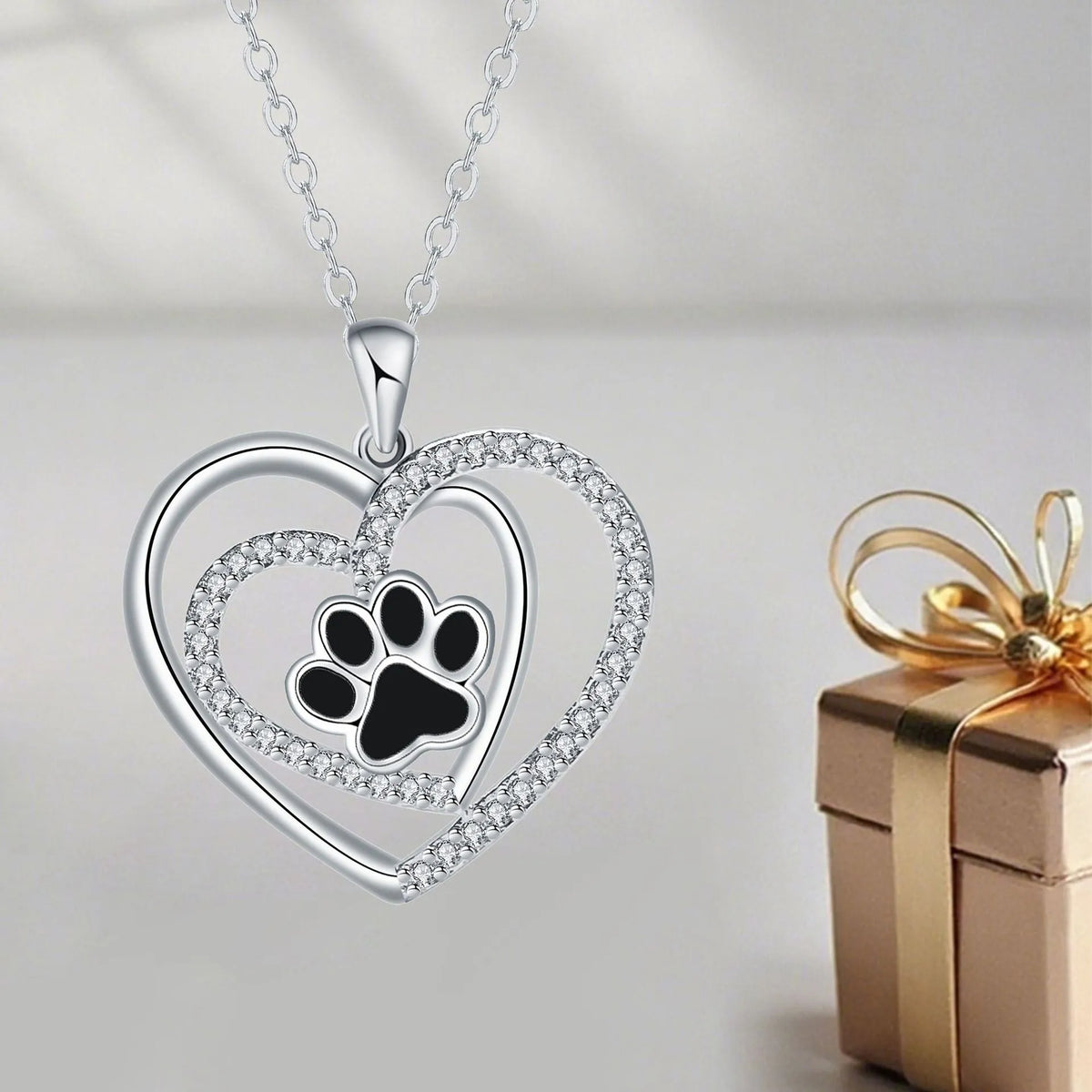 Women's copper necklace with a heart and dog paw prints pendant on a cross chain.
