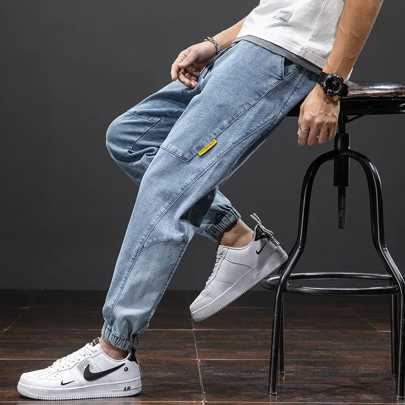 Man wearing straight leg cotton cargo jeans in blue, showing mid waist and skinny open leg style.