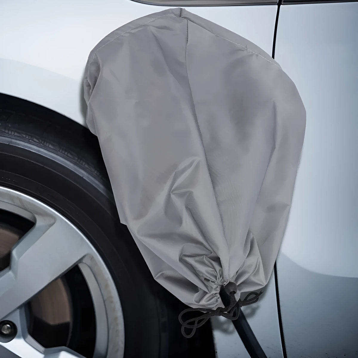 Grey waterproof drawstring cover for an electric vehicle charging port.