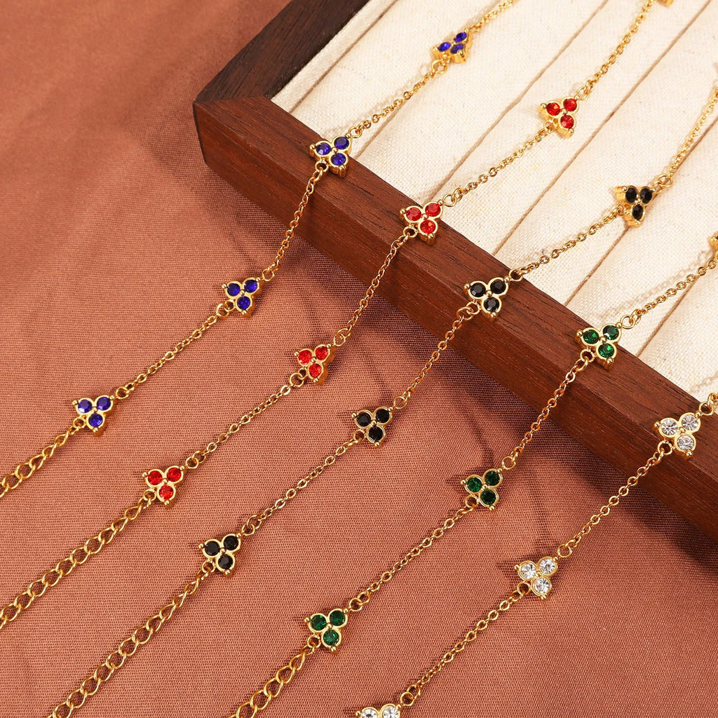 Women's stainless steel geometric bracelet with three diamonds and a coloured zircon stone in a triangular setting.