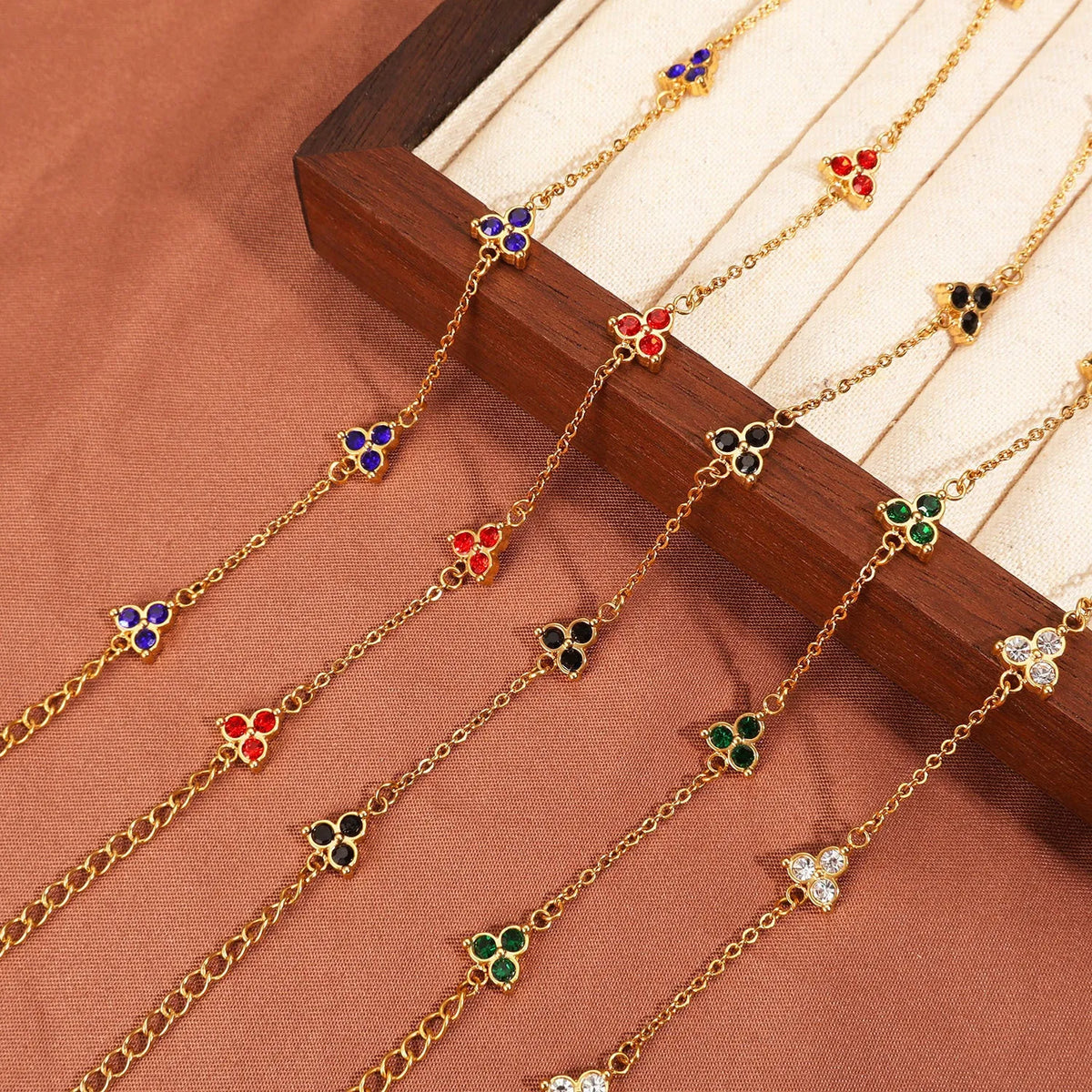 Women's stainless steel geometric bracelet with three diamonds and a coloured zircon stone in a triangular setting.