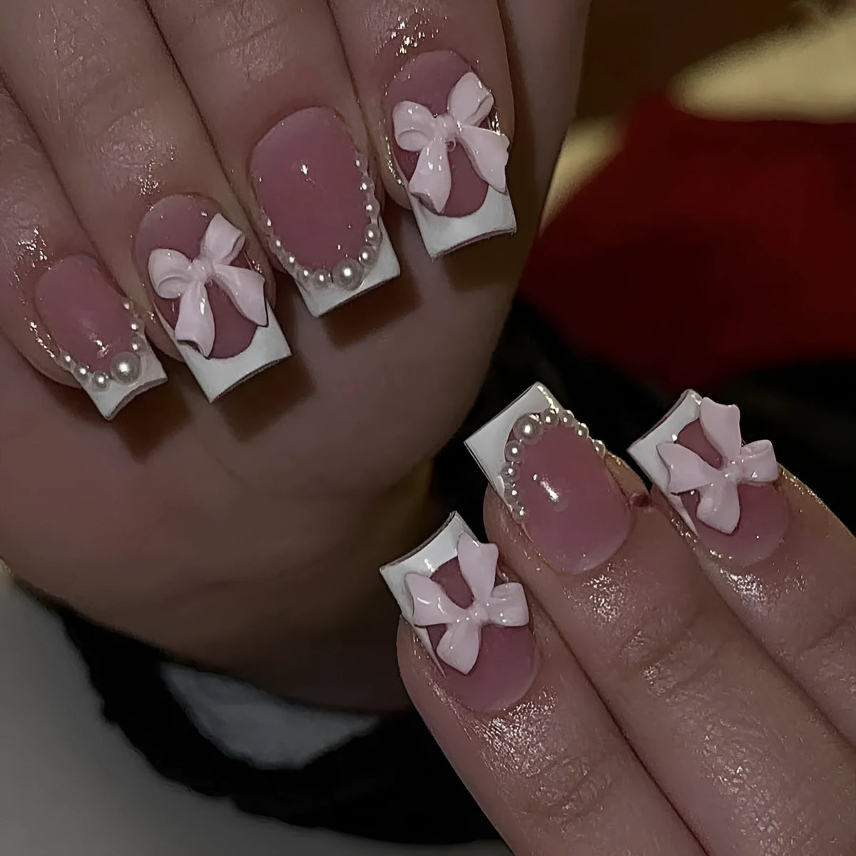 Short white French manicure false nails with decorative bow and tulip designs.