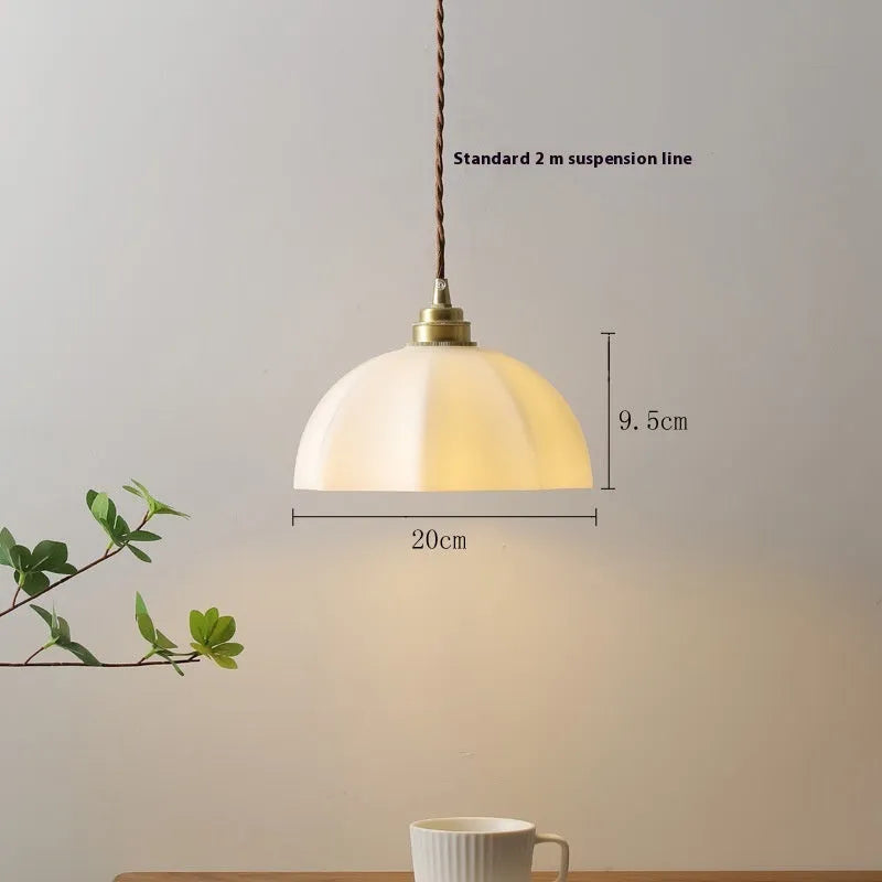 Brass Chinese style pendant light with copper glass shade hanging from ceiling