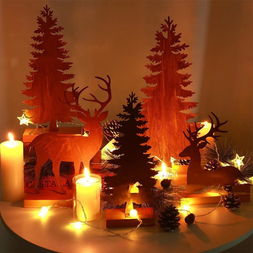 Three rusty metal Christmas decorations featuring elk and trees on a wooden surface