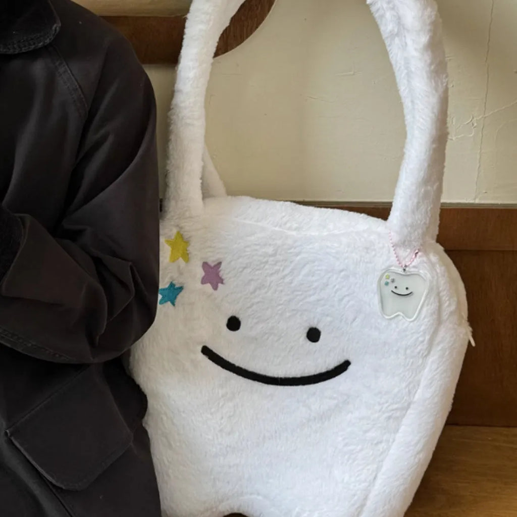 White plush shoulder tote bag with large tooth design and cute teeth pattern, showing zipper closure