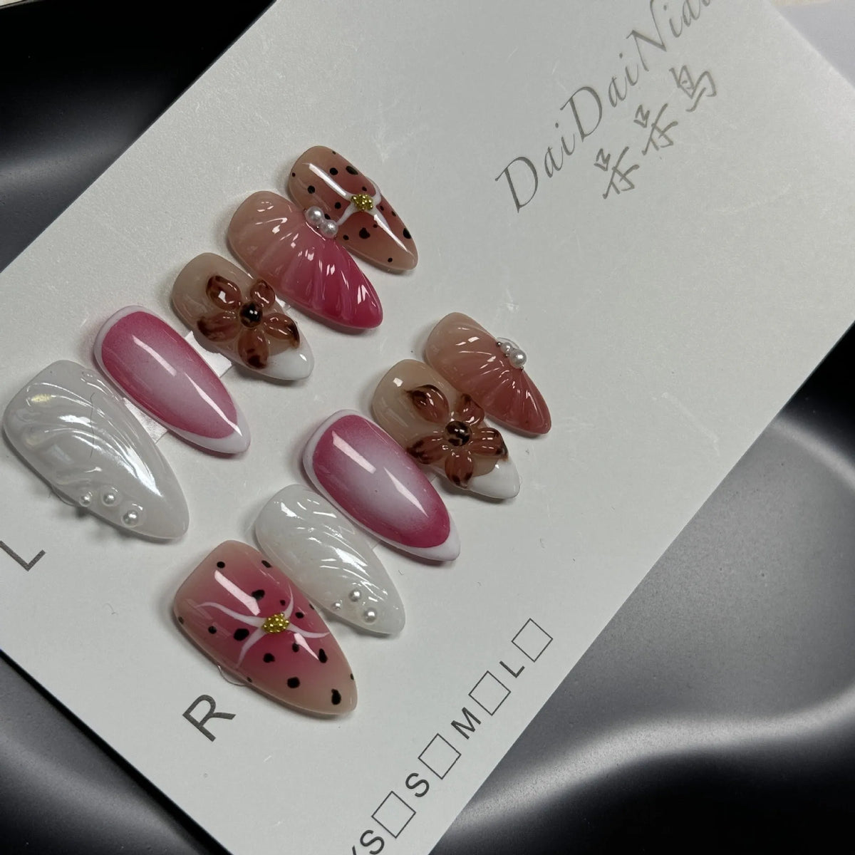 Close-up of hand-painted 3D nail patch with embossed candy pattern on an almond-shaped nail.