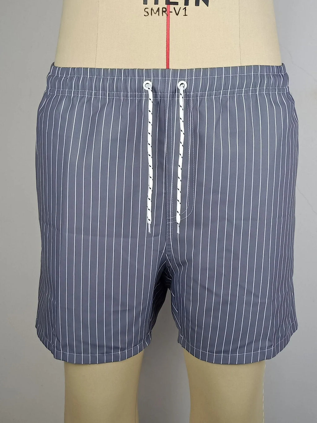 Navy blue striped beach shorts with straight leg opening and triangle lining, flat lay.