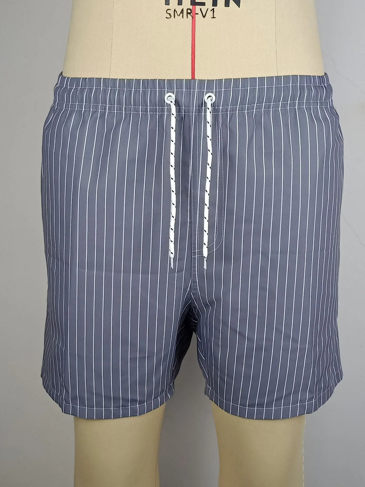 Navy blue striped beach shorts with straight leg opening and triangle lining, flat lay.