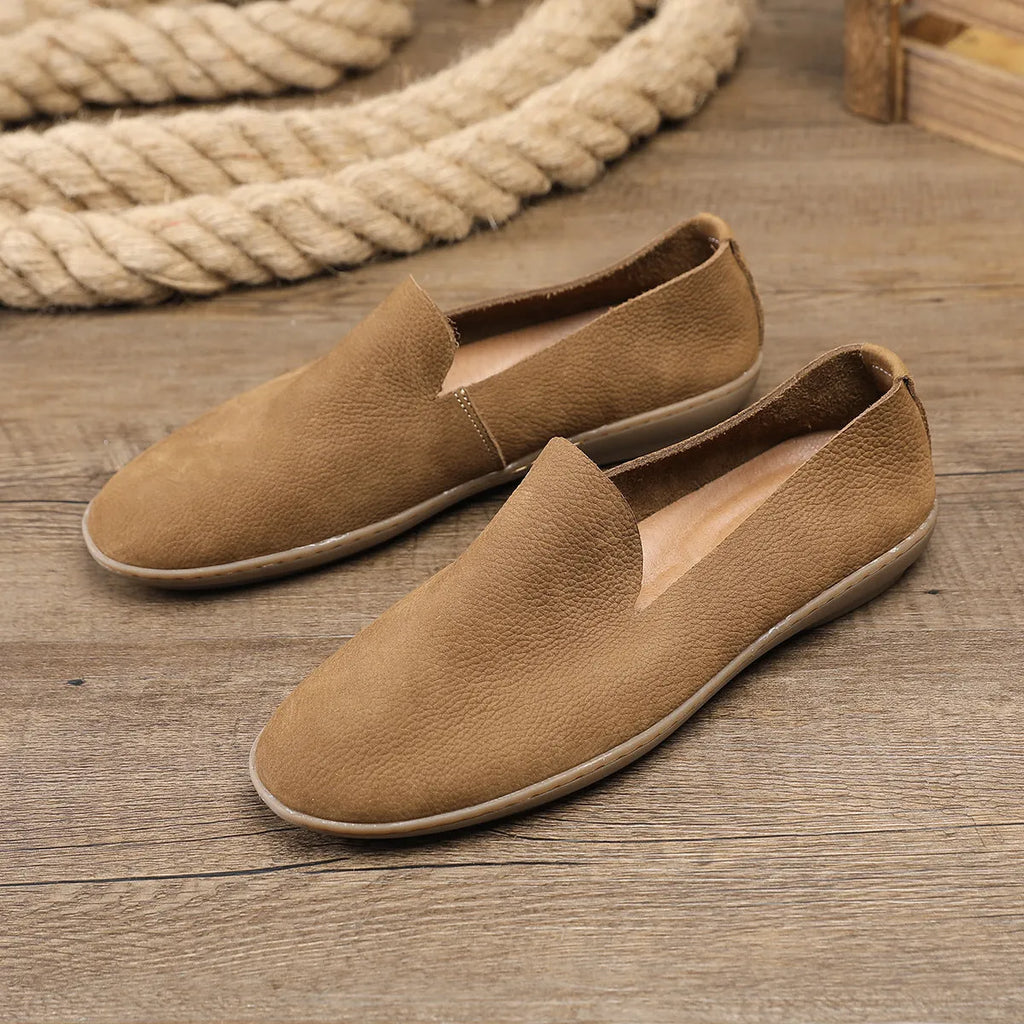 Handmade grey low-top men's shoes with a flat wedge heel and rubber sole.