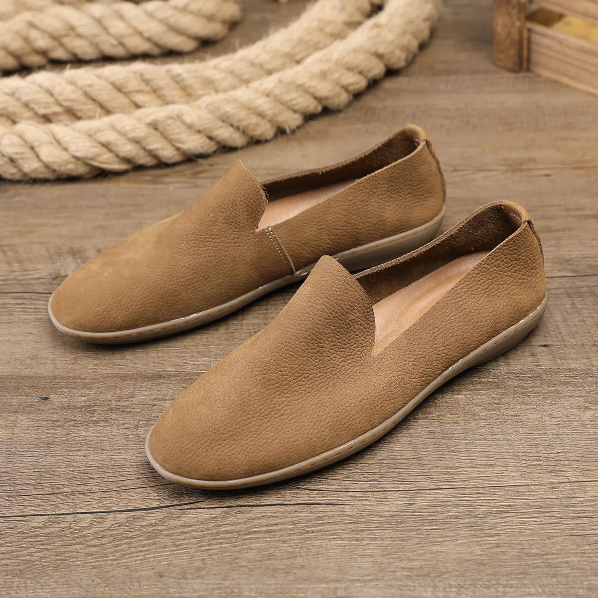 Handmade grey low-top men's shoes with a flat wedge heel and rubber sole.