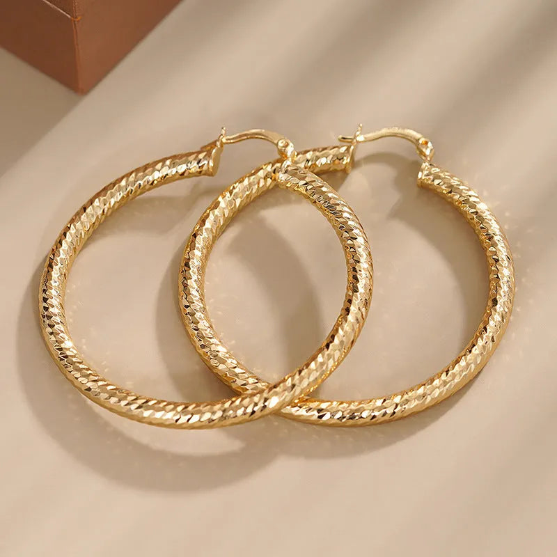 Women's geometric drop-shaped ear clips with ring and line elements in copper electroplated finish