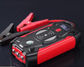 Red portable car jump starter unit with booster clamps and charger in storage box
