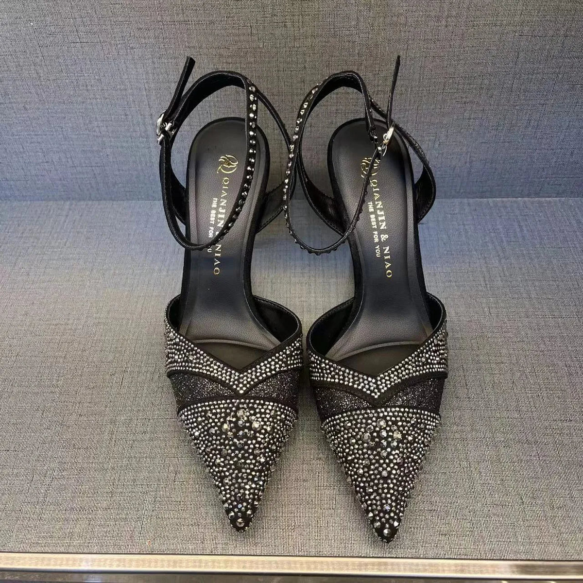 Women's black hollow high heels with stiletto heel, pointed toe, and red sole