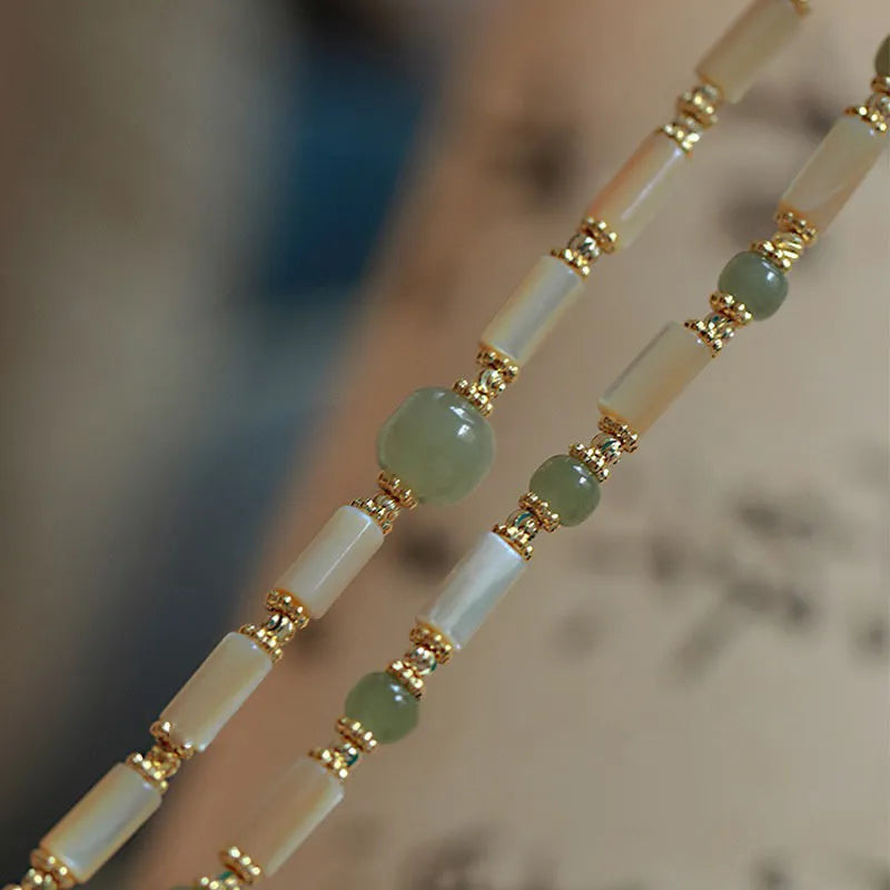 A women's adjustable bracelet made of round white Hetian jade beads in a simple geometric design.