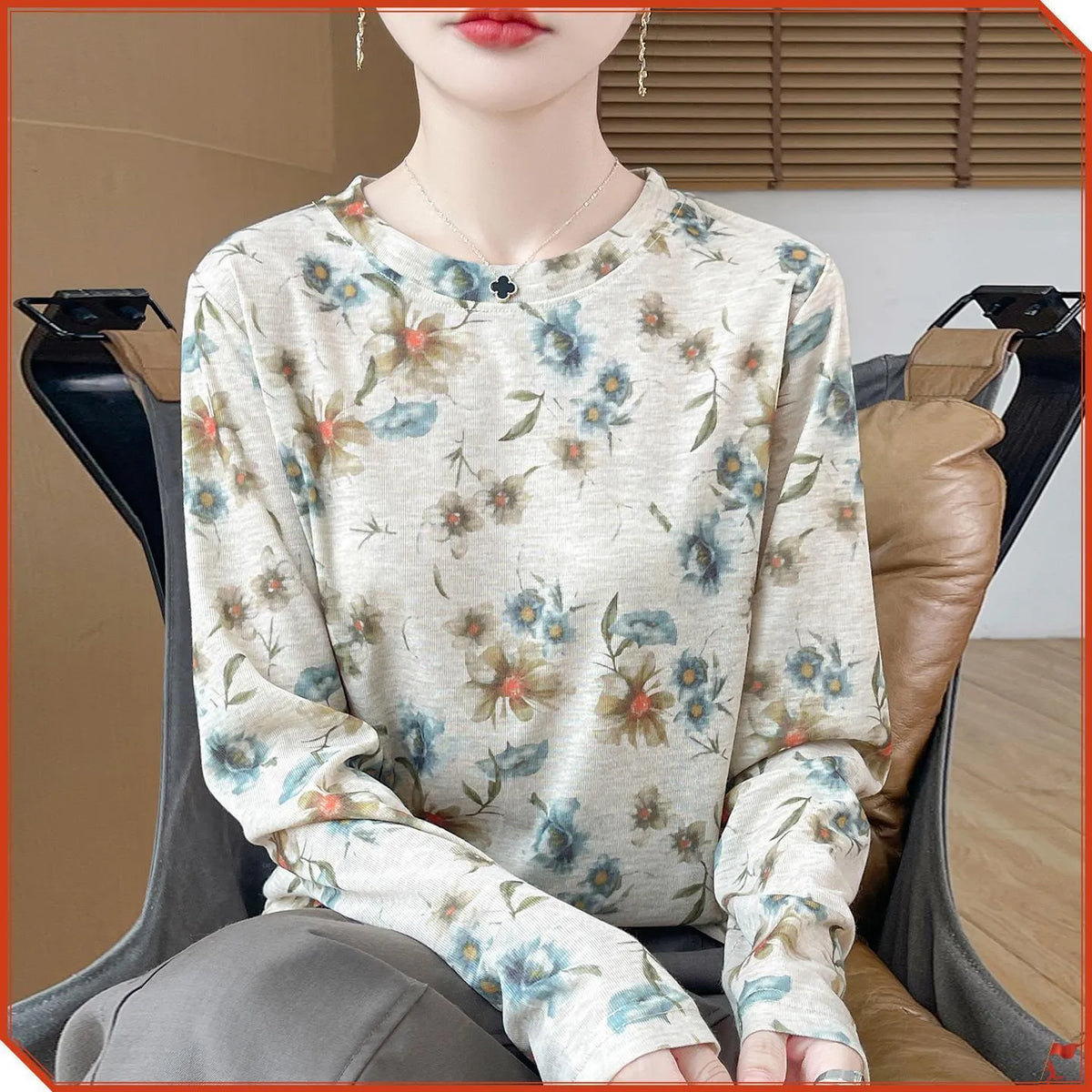 Floral print round neck pullover in knitted Tencel cotton fabric on a hanger.