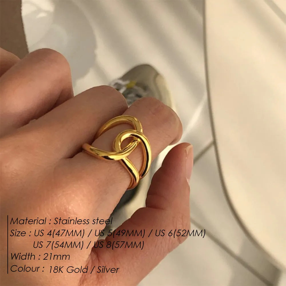 A gold-coloured geometric U-shaped ring with an adjustable opening and a knotted detail.
