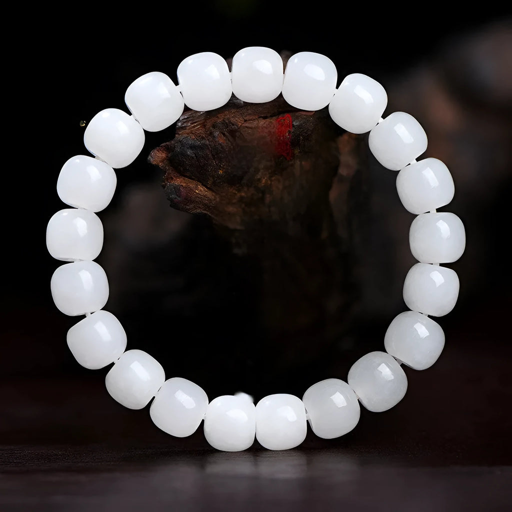 White Hetian jade barrel bead bracelet on a wrist, showing the smooth beads and casual unisex design.