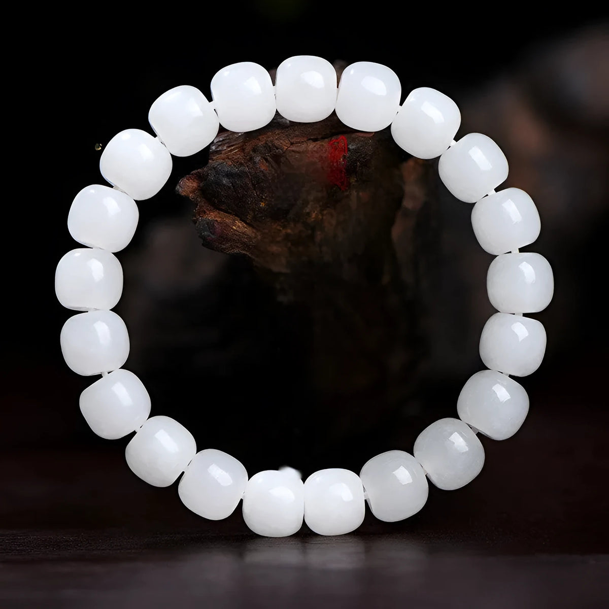 White Hetian jade barrel bead bracelet on a wrist, showing the smooth beads and casual unisex design.