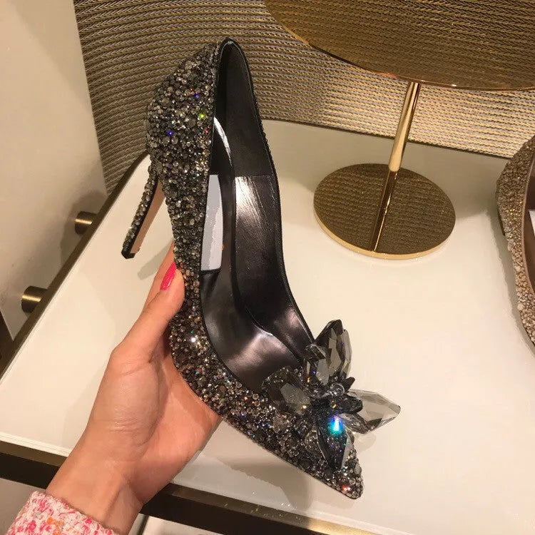 Women's gold stiletto high heels with rhinestone and bow decorations on pointed toe.