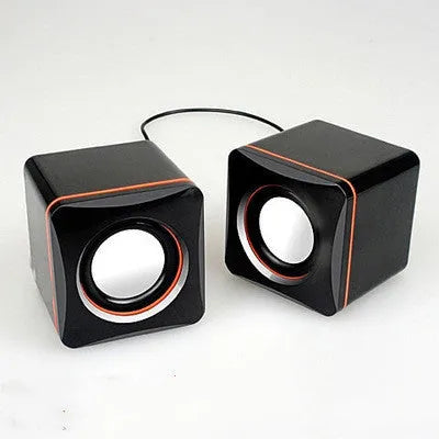 Black square USB-powered 2.0 computer speaker on desk with single cable connection