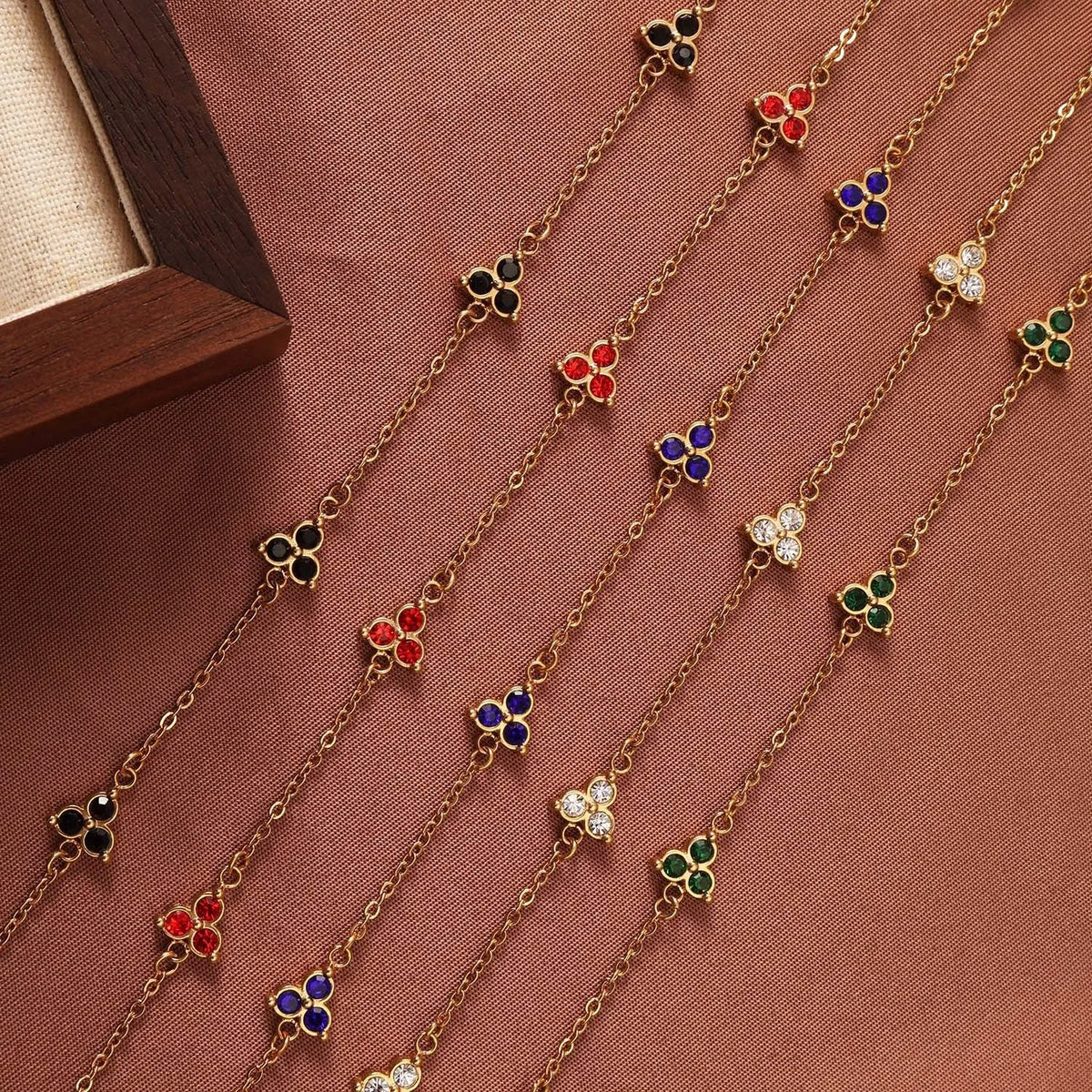 Women's stainless steel geometric bracelet with three diamonds and a coloured zircon stone in a triangular setting.