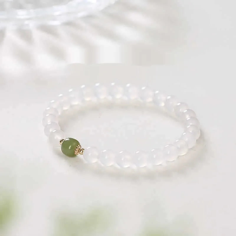Handmade white agate and Hetian jade bracelet with red cinnabar inlay and a text charm.