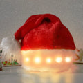 Red and white plush LED Santa hat with pom-pom and multi-colour twinkling lights on model.