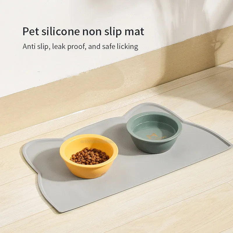 Blue waterproof silicone pet feeding mat for dog and cat bowls on a wooden floor