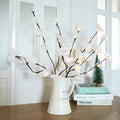 Pink phalaenopsis branch LED decorative light with fabric stem and plastic housing on wooden table