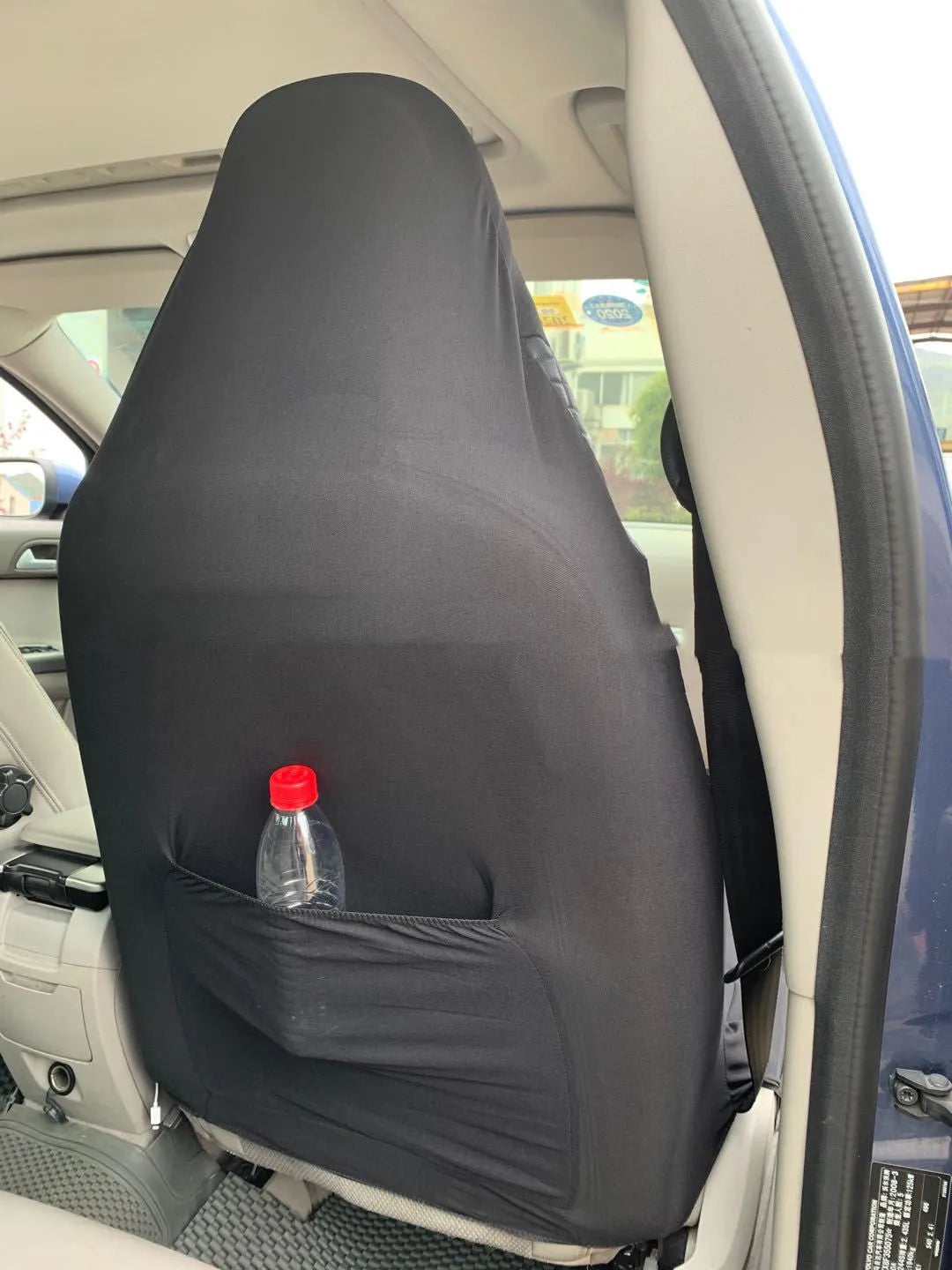 Black quilted automotive seat cover with PU polyester construction and sponge padding including plastic mounting hooks
