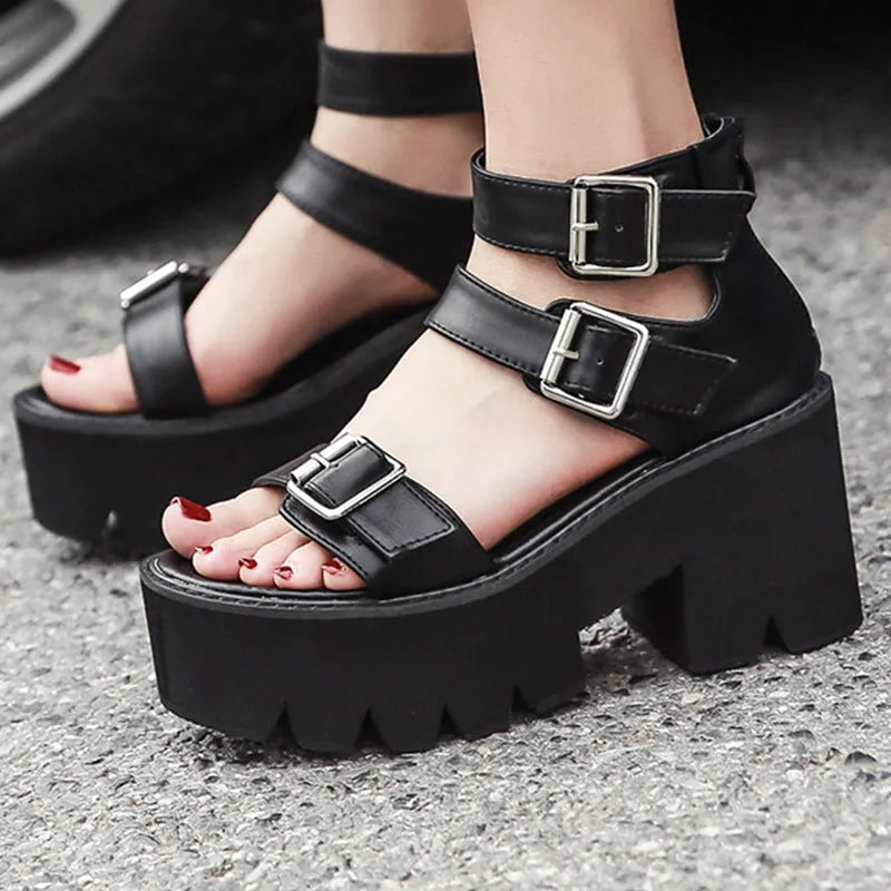 Black punk-style women's sandals with a chunky heel, thick platform sole, and back zipper.