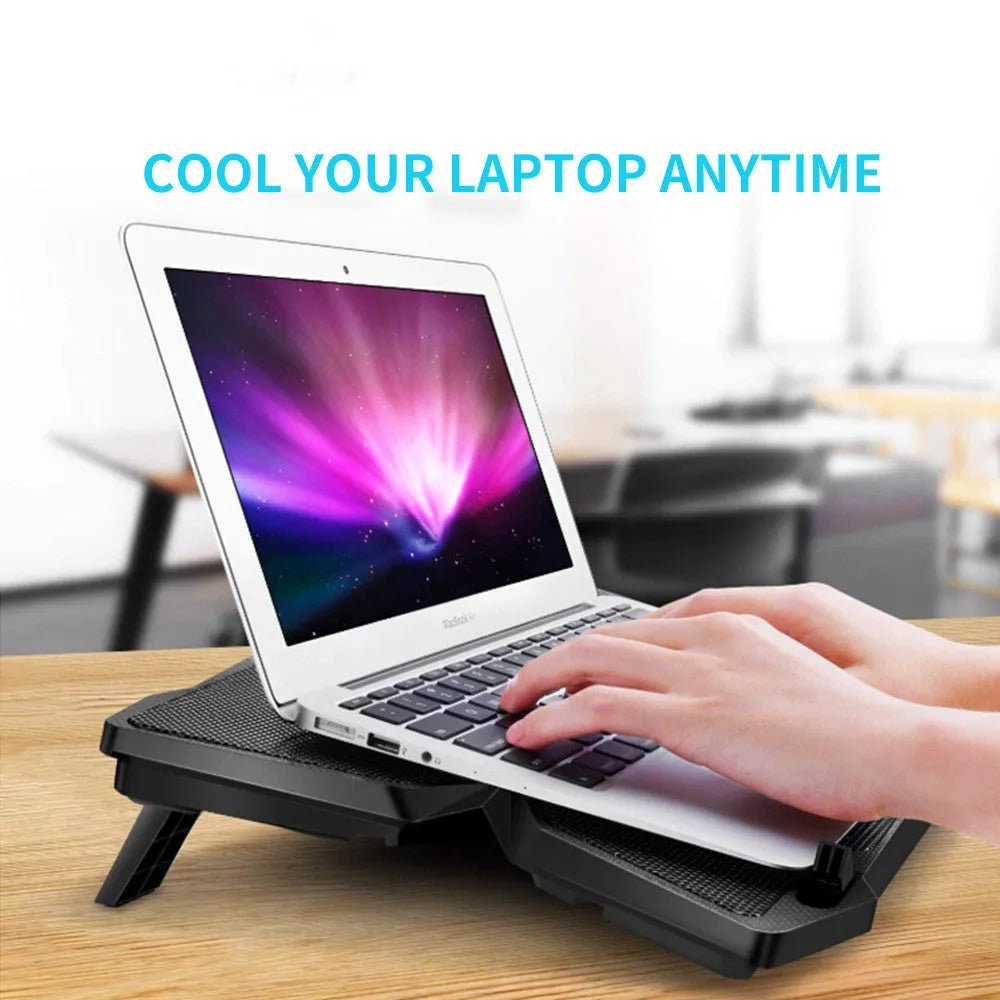 Blue laptop cooling base with four fans and USB ports on computer desk