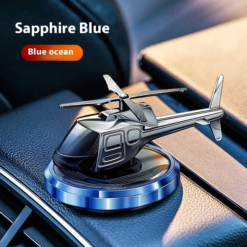 Silver solar powered rotating helicopter car perfume ornament on vehicle dashboard