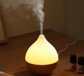 Wood grain finish vase-shaped aroma diffuser with 100ml water tank capacity.