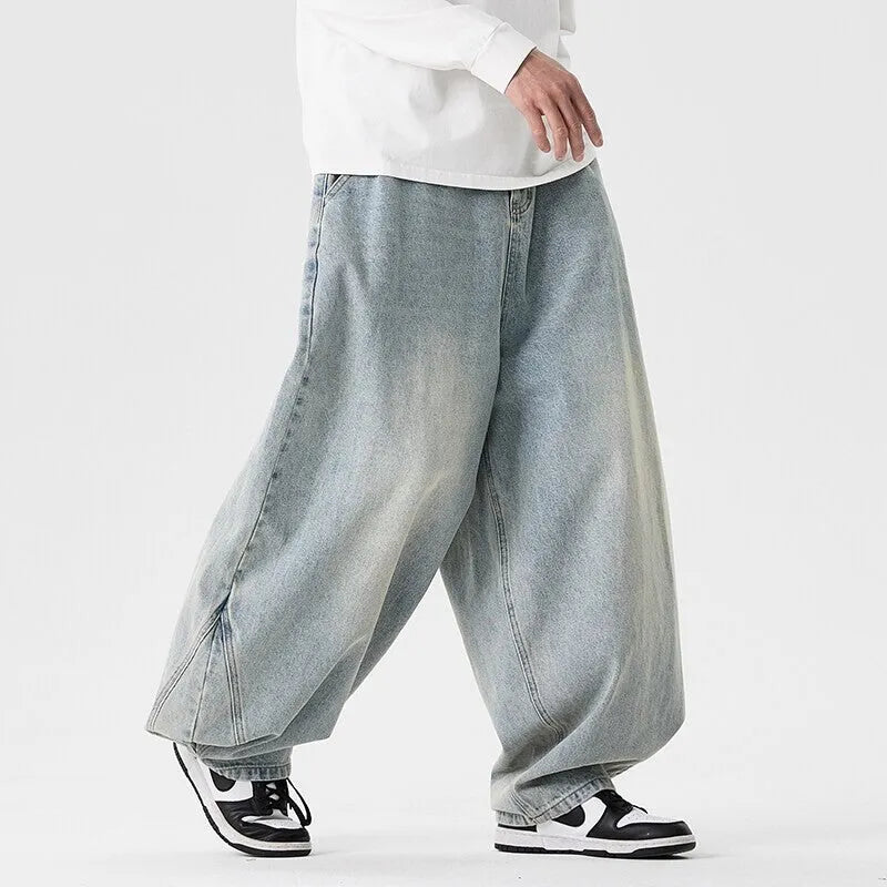 Men's loose fit light blue denim jeans with a straight leg and low waist, laid flat.