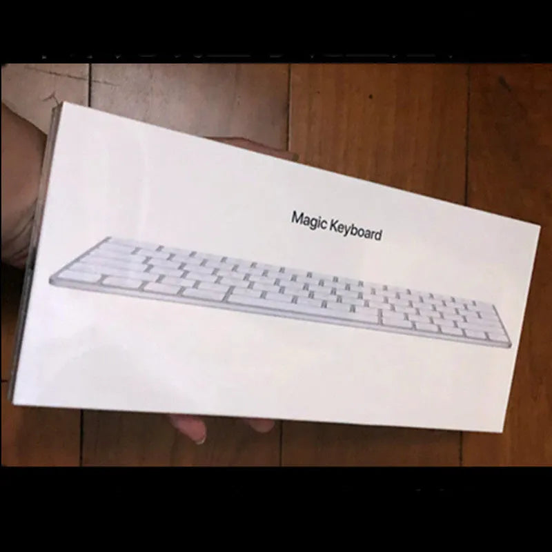 White genuine Apple Bluetooth wireless keyboard with ultra-thin metal casing on a desk.