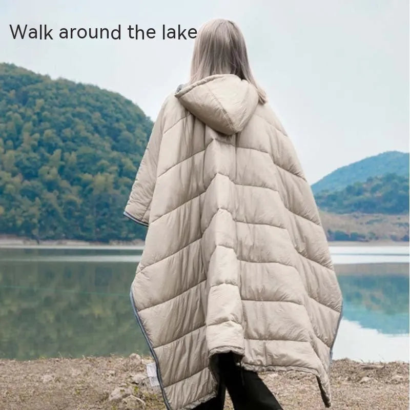 Adult wearing a grey outdoor cloak sleeping bag, showing its full 200x140cm size and hood.