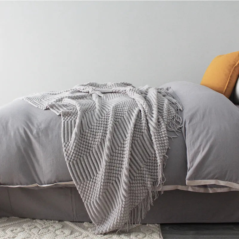 Small grey polyester nap blanket folded to show its size and texture.