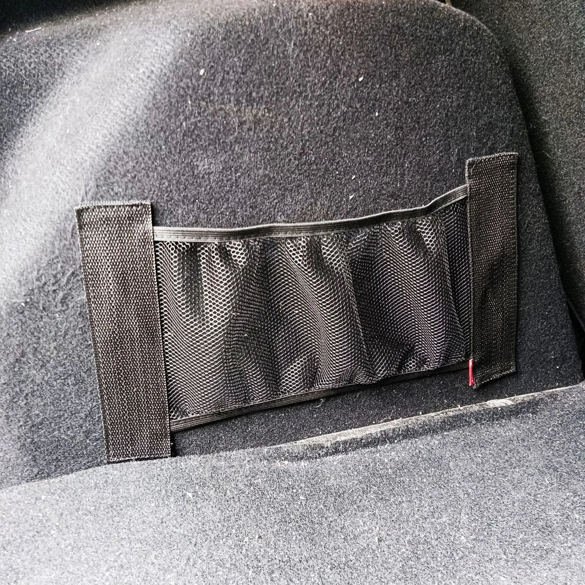 Elastic polyester mesh car boot storage organiser net shown in a vehicle trunk.