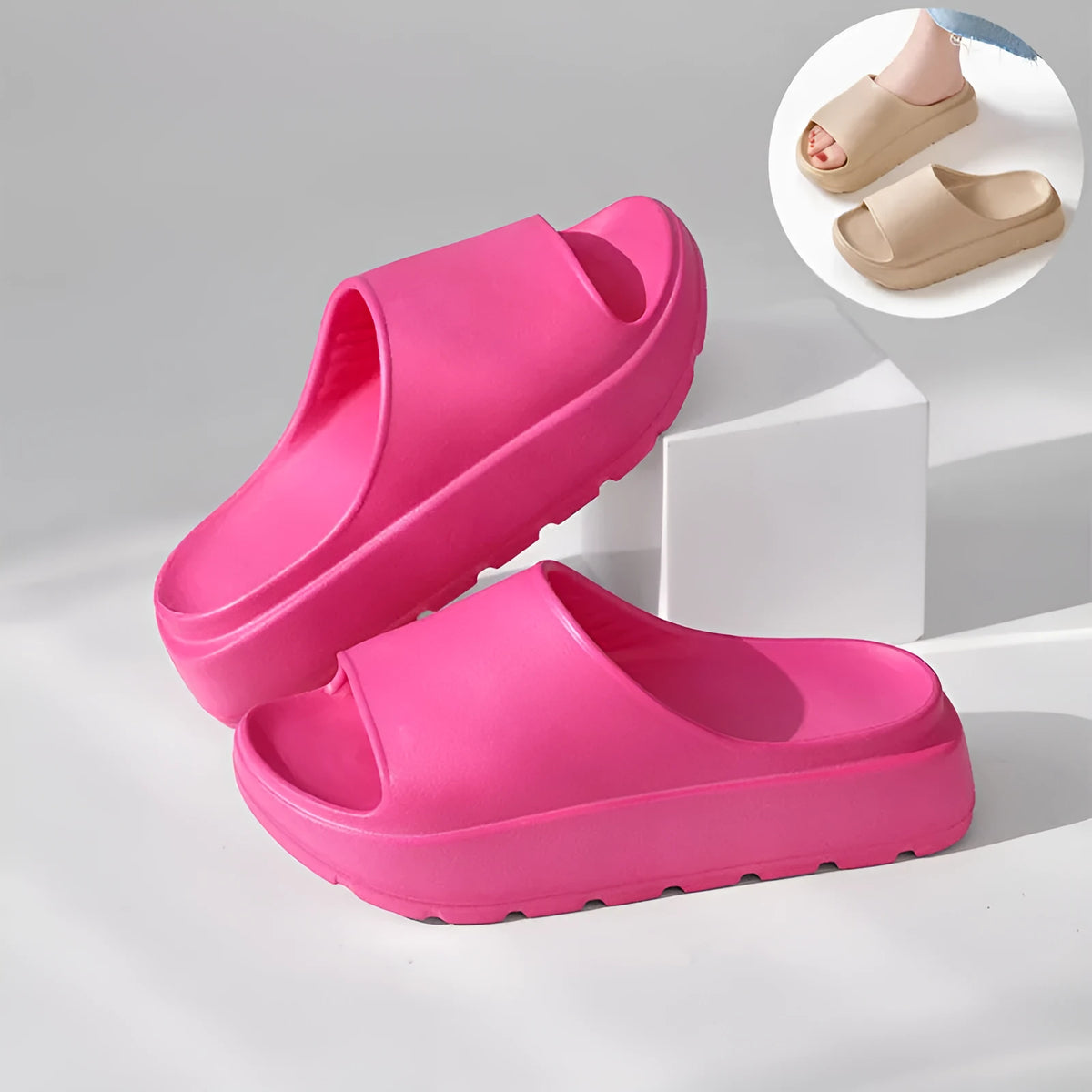 Women's thick-soled beige beach slippers with fish mouth design on a wooden deck.