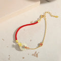 Women's silver bracelet with gold koi design and red rope adjustment
