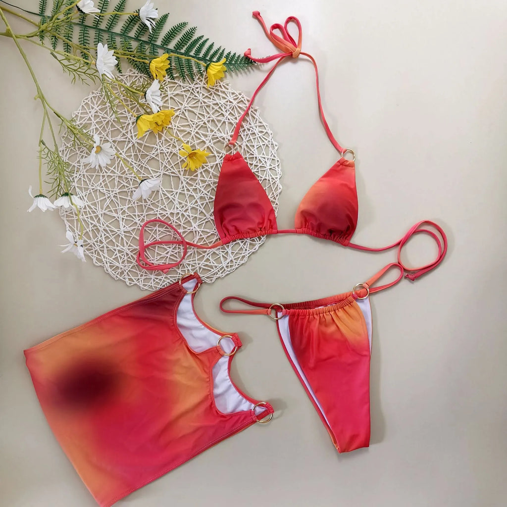 Tie-dye gradient patterned three-piece halter bikini swimsuit set with a skirt on a solid colour background.
