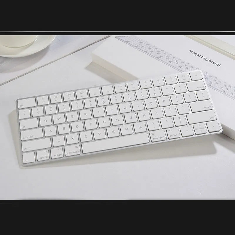 White genuine Apple Bluetooth wireless keyboard with ultra-thin metal casing on a desk.