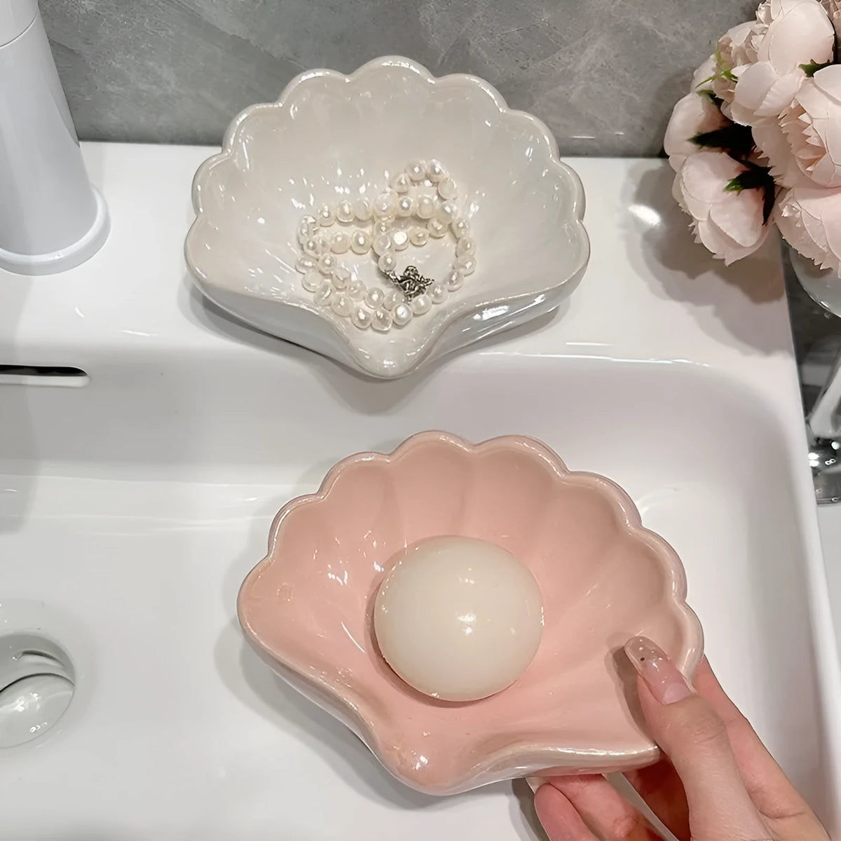 Shell-shaped white plastic soap dish with drainage for bathroom use