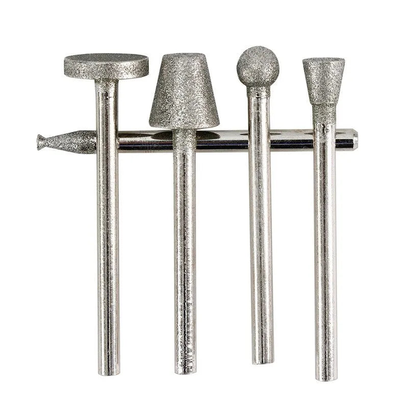 Close-up of an elliptical cone shaped alloy grinding head with a 3mm shank on a textured surface.
